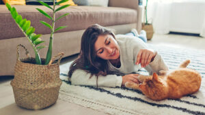 woman playing with cat at home